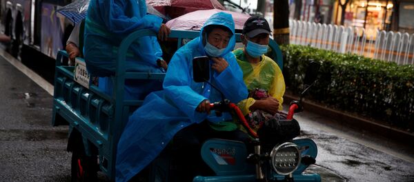 Рабочие в защитных масках и дождевиках на электрическом трицикле в дождливый день после вспышки коронавирусной болезни (COVID-19) в Пекине - 俄罗斯卫星通讯社
