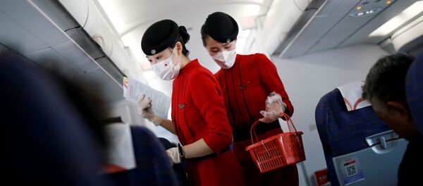 Стюардессы в защитных масках на борту самолета  авиакомпании Sichuan Airlines - 俄羅斯衛星通訊社