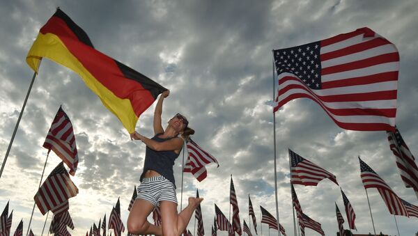 Девушка прыгает с флагом Германии на фоне американских флагов - 俄罗斯卫星通讯社