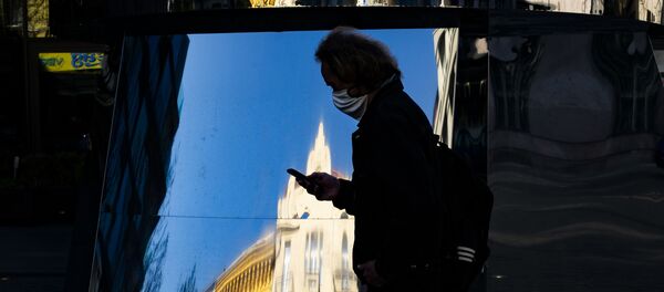 Прохожий в медицинской маске и с мобильным телефоном в Праге - 俄罗斯卫星通讯社