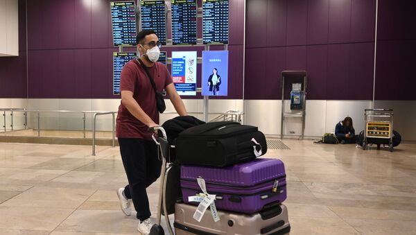 Пассажир в медицинской маске и с чемоданами в международном аэропорту Барахас в Мадриде - 俄罗斯卫星通讯社