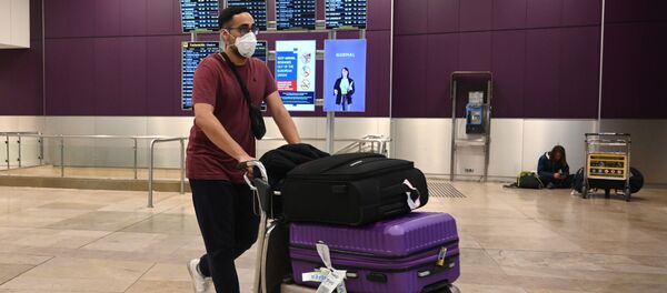 Пассажир в медицинской маске и с чемоданами в международном аэропорту Барахас в Мадриде - 俄罗斯卫星通讯社