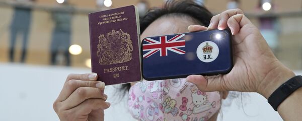 A protester holds a British National (Overseas) passport - 俄罗斯卫星通讯社