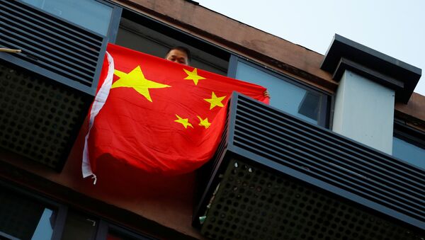 Мужчина с флагом Китая в доме напротив консульства США в Чэнду - 俄羅斯衛星通訊社