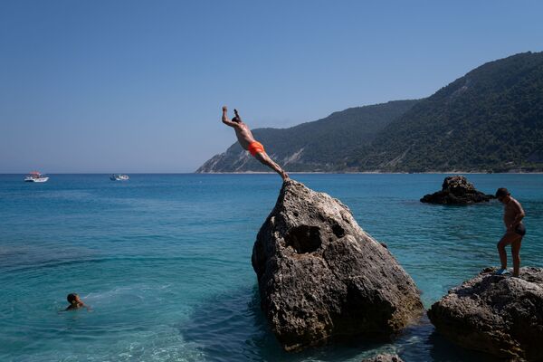 Мужчина ныряет на пляже Агиос Никитас после смягчения мер по борьбе с распространением коронавируса на острове Лефкас, Греция - 俄罗斯卫星通讯社