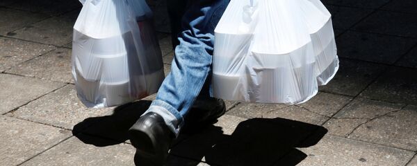 Мужчина несет пластиковые контейнеры с едой. Гонконг - 俄羅斯衛星通訊社