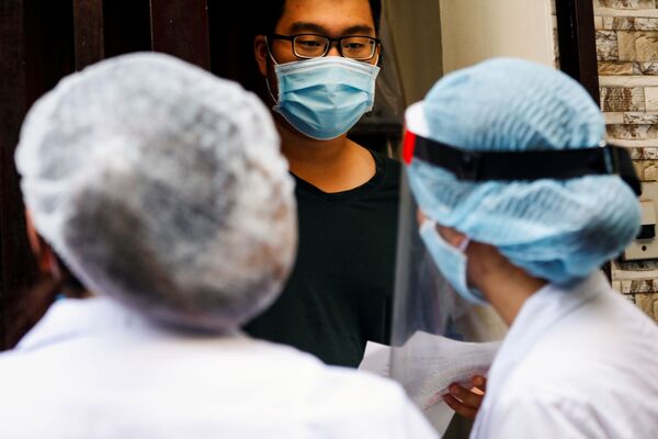 Медицинские работники беседуют с местным жителем возле дома пациента с коронавирусном в Ханое, Вьетнам - 俄罗斯卫星通讯社