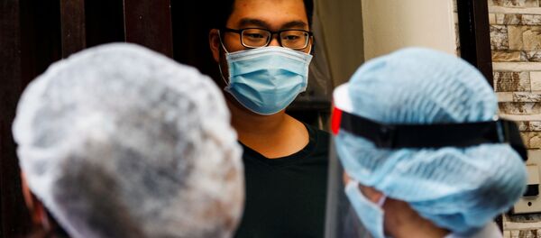 Медицинские работники беседуют с местным жителем возле дома пациента с коронавирусном в Ханое, Вьетнам - 俄罗斯卫星通讯社