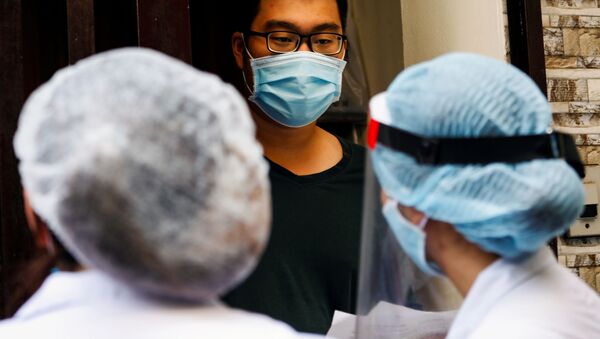 Медицинские работники беседуют с местным жителем возле дома пациента с коронавирусном в Ханое, Вьетнам - 俄罗斯卫星通讯社