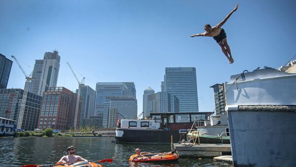 Мужчина ныряет в воду в лондонском районе Доклендс, Англия - 俄罗斯卫星通讯社