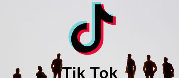 Фигурки на фоне логотипа социальной сети TikTok  - 俄罗斯卫星通讯社