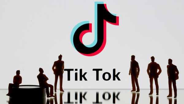 Фигурки на фоне логотипа социальной сети TikTok  - 俄羅斯衛星通訊社