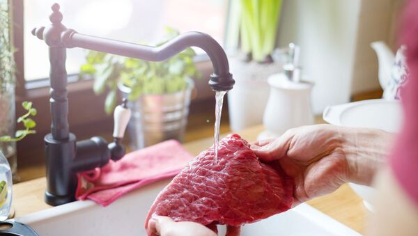 Мытье куска сырого мяса под струей воды - 俄罗斯卫星通讯社