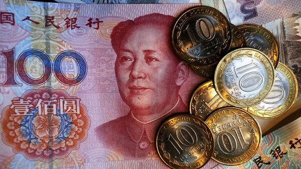 Китайская банкнота номиналом в 100 юаней и российские 10 рублевые монеты.  - 俄羅斯衛星通訊社