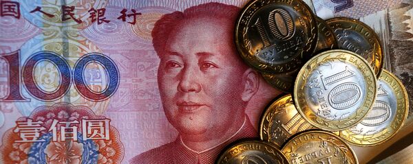 Китайская банкнота номиналом в 100 юаней и российские 10 рублевые монеты.  - 俄罗斯卫星通讯社