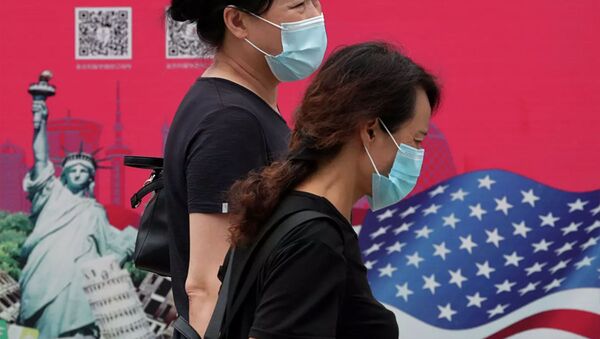 Женщины в защитных масках проходят мимо рекламного щита в Пекине - 俄罗斯卫星通讯社