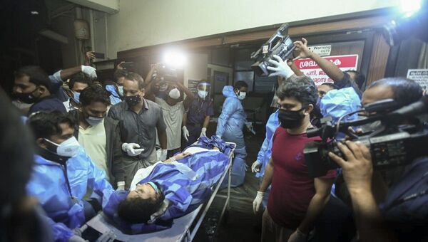 One of the persons injured after an Air India Express flight skidded off a runway while landing at the Kozhikode airport is brought for treatment to the Medical College Hospital in Kozhikode, Kerala state, India, Friday, Aug. 7, 2020. (AP Photo) - 俄罗斯卫星通讯社