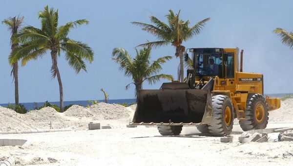 A bulldozer makes it's way past palm trees, 18 October 2003, on Hulhumale, an artificial island reclaimed from a lagoon to lodge Maldives' ever-growing population. - 俄羅斯衛星通訊社