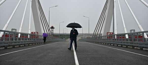 17 августа 2020. Мужчина под зонтом на автомобильном мосту через Амур между Благовещенском и китайским Хэйхе. - 俄羅斯衛星通訊社