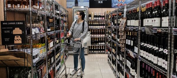 Девушка выбирает вино в супермаркете - 俄罗斯卫星通讯社