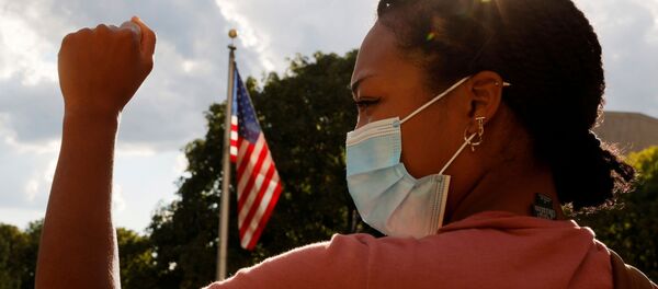 Девушка в медицинской маске на фоне флага США - 俄罗斯卫星通讯社