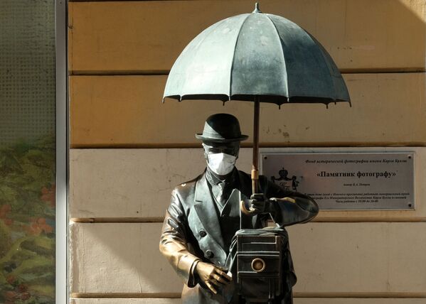 Памятник фотографу с надетой медицинской маской на Малой Садовой улице в Санкт-Петербурге - 俄罗斯卫星通讯社