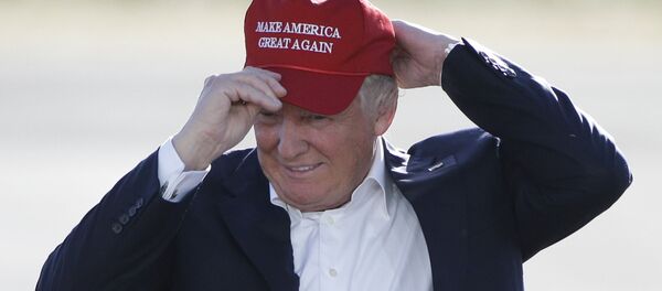 Дональд Трамп надевает кепку с надписью Make America great again - 俄罗斯卫星通讯社