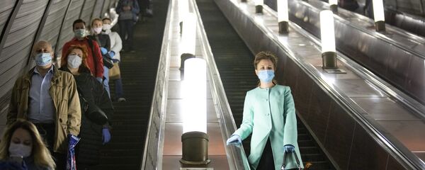 Люди в защитных масках и перчатках на эскалаторе московского метро - 俄罗斯卫星通讯社