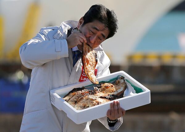 Премьер-министр Японии Синдзо Абэ ест местную жареную рыбу в порту Сома Харагама - 俄羅斯衛星通訊社