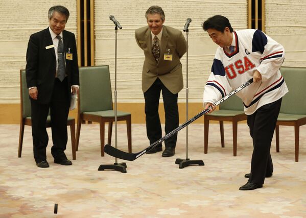 Премьер-министр Японии Синдзо Абэ делает бросок шайбы во время встречи с представителями хоккейной команды Yosaku - 俄罗斯卫星通讯社