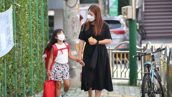 Мама с дочерью в медицинских масках по дороге в начальную школу в Сеуле, Южная Корея - 俄罗斯卫星通讯社