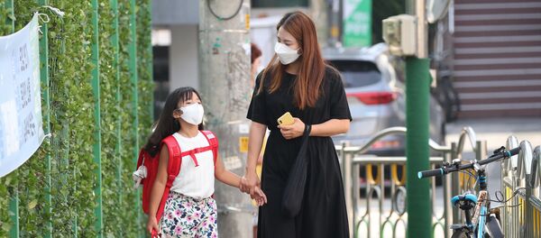 Мама с дочерью в медицинских масках по дороге в начальную школу в Сеуле, Южная Корея - 俄羅斯衛星通訊社