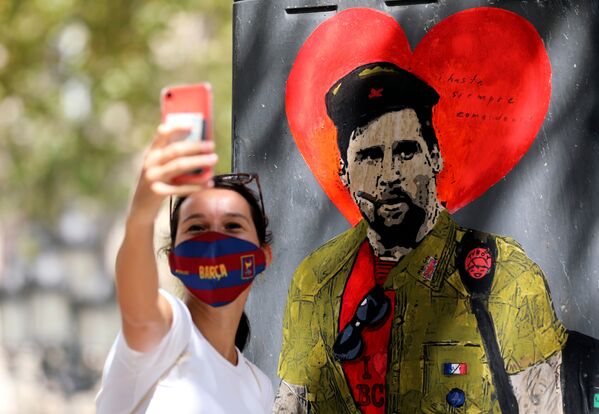 Девушка фотографируется напротив граффити с изображением игрока ФК Барселона Лионель Месси в Испании  - 俄罗斯卫星通讯社