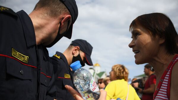 Сотрудники правоохранительных органов и участница акции протеста в Минске. - 俄羅斯衛星通訊社