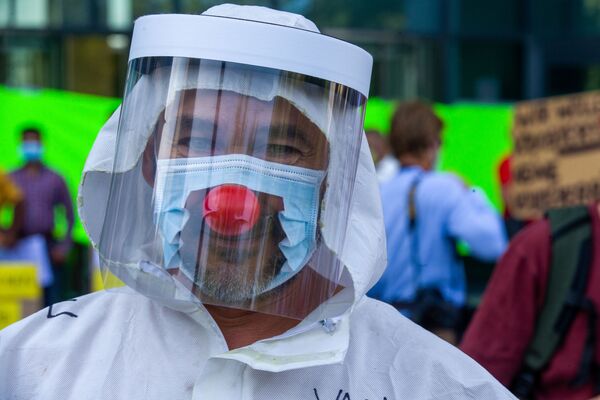 Мужчина в маске и с клоунским носом во время протестов в Брюсселе - 俄罗斯卫星通讯社