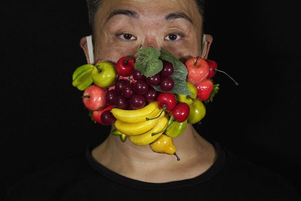 Гонконгский театральный художник по костюмам и актер Эдмонд Кок в маске, украшенной множеством разных фруктов - 俄罗斯卫星通讯社