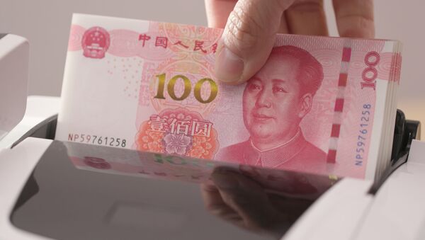 Счетчик денег проверяет номера банкнот пачки китайских юаней  - 俄罗斯卫星通讯社