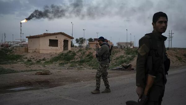 Поддерживаемый США боец Сирийских демократических сил (SDF) разговаривает по рации на контрольно-пропускном пункте возле нефтяной базы Омар, восточная Сирия - 俄羅斯衛星通訊社