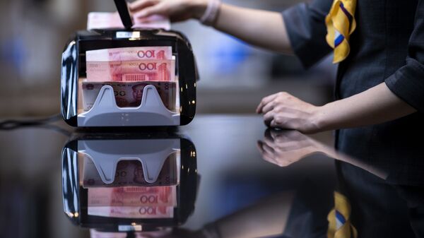 Пачка китайских юаней в машинке для подсчета банкнот - 俄罗斯卫星通讯社