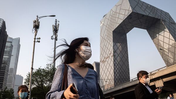 Люди в медицинских масках и с мобильными телефонами на фоне сотовой 5G-вышки в Пекине, Китай - 俄罗斯卫星通讯社