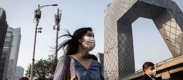 Люди в медицинских масках и с мобильными телефонами на фоне сотовой 5G-вышки в Пекине, Китай - 俄罗斯卫星通讯社