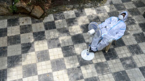 Медицинский работник отдыхает, ожидая сбора мазков для тестов на коронавирус в центре общественного здравоохранения в Хайдарабаде  - 俄罗斯卫星通讯社
