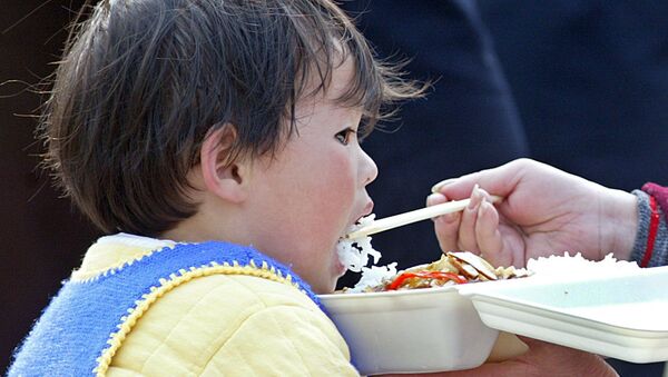 Маленького ребенка кормят рисом - 俄羅斯衛星通訊社