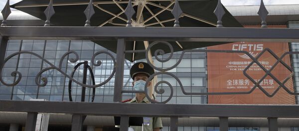 Полицейский в маске на входе торговой ярмарки в Пекине. Полицейский в маске на входе торговой ярмарки в Пекине. - 俄羅斯衛星通訊社