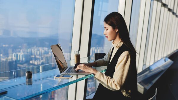 Азиатская девушка работает за ноутбуком - 俄羅斯衛星通訊社