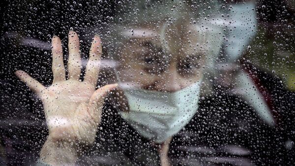 Женщина в маске прощается из машины - 俄罗斯卫星通讯社