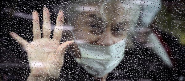 Женщина в маске прощается из машины - 俄罗斯卫星通讯社