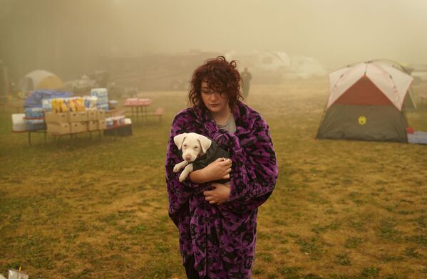 Женщина держит свою собаку, завернутую в одеяло, в центре эвакуации  от лесных пожаров в Оук-Гроув, штат Орегон - 俄羅斯衛星通訊社