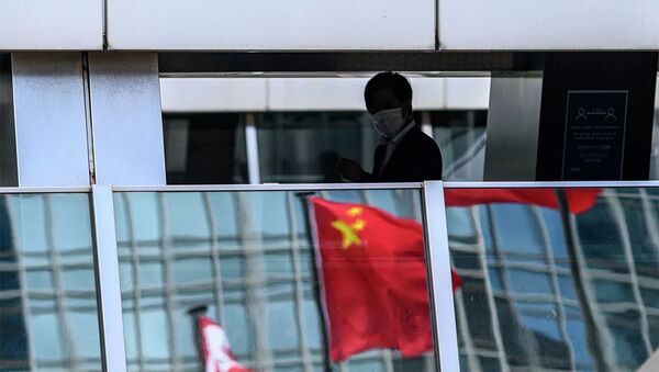 Мужчина на пешеходном мосту, в котором отражается флаг Китая, Гонконг - 俄羅斯衛星通訊社