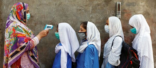 Проверка температуры у учеников перед входом в класс в Пешаваре, Пакистан Проверка температуры у учеников перед входом в класс в Пешаваре, Пакистан - 俄羅斯衛星通訊社